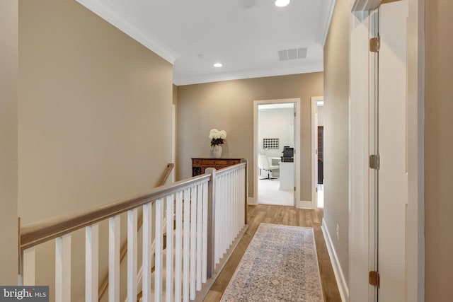 hallway with visible vents, crown molding, an upstairs landing, light wood-style floors, and recessed lighting