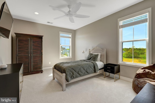 bedroom with light colored carpet, baseboards, visible vents, and multiple windows