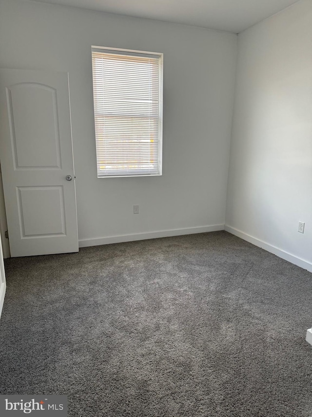 unfurnished room featuring carpet floors and baseboards