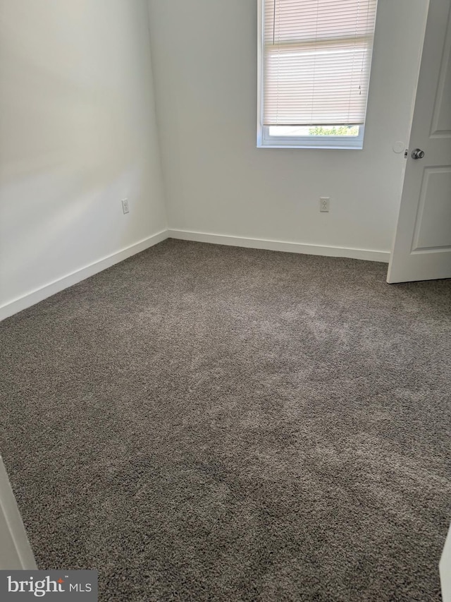 empty room featuring carpet floors and baseboards