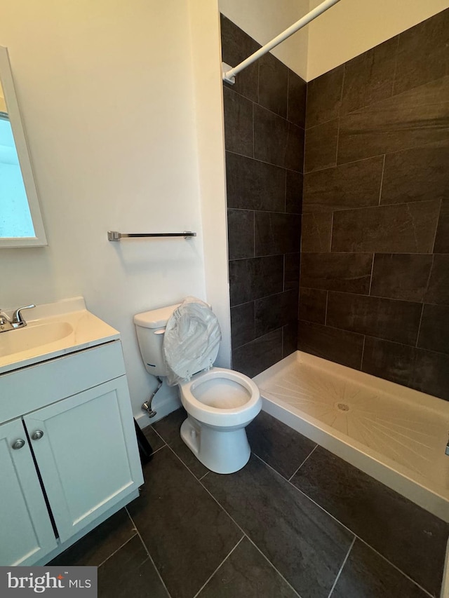 bathroom with a stall shower, tile patterned flooring, vanity, and toilet