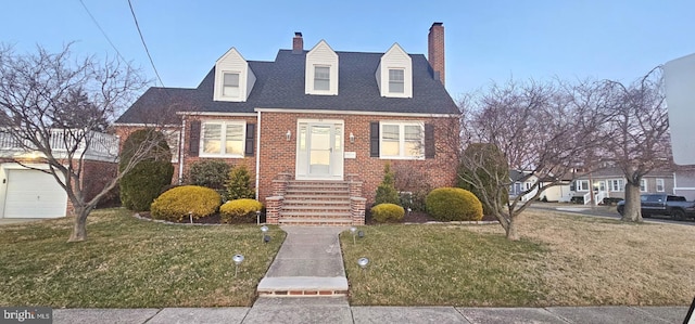 cape cod house featuring a front yard, brick siding, and a chimney