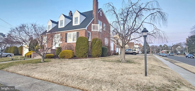 view of home's exterior with brick siding and a lawn