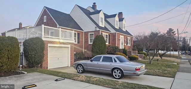 view of home's exterior featuring brick siding, driveway, a chimney, and roof with shingles