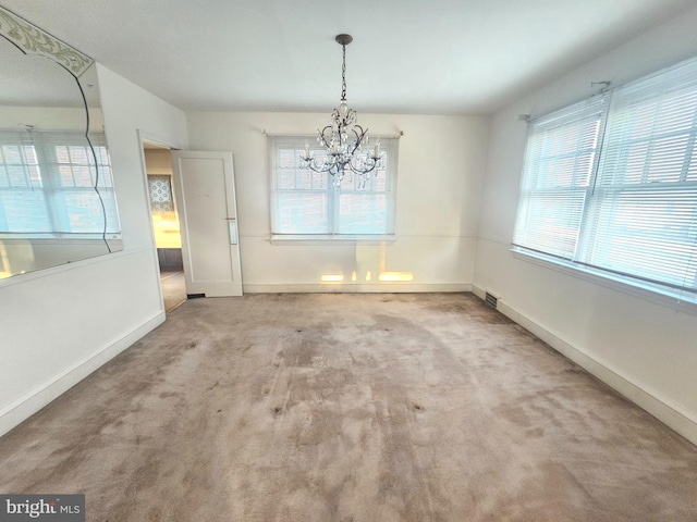 unfurnished dining area featuring an inviting chandelier, carpet, baseboards, and visible vents