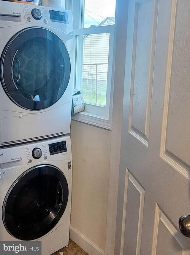 laundry area featuring stacked washer / drying machine
