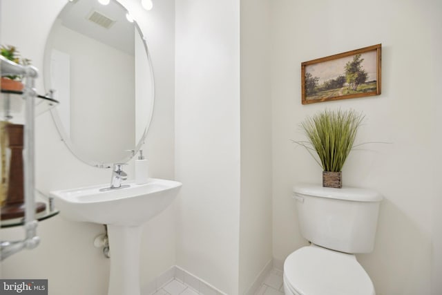 half bath featuring visible vents, toilet, and baseboards