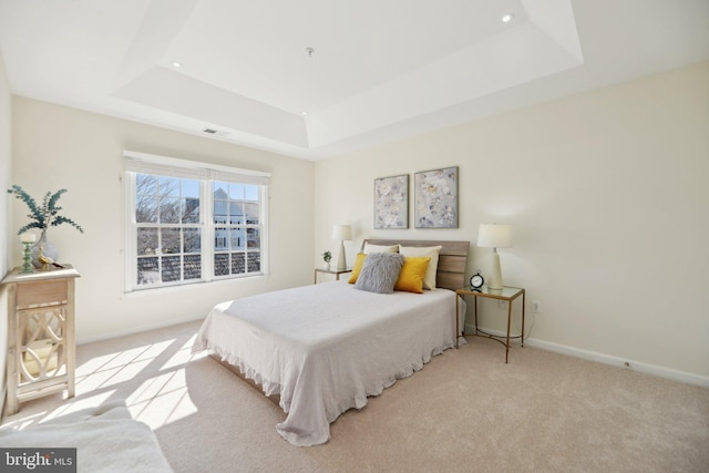 carpeted bedroom with recessed lighting, a tray ceiling, baseboards, and visible vents