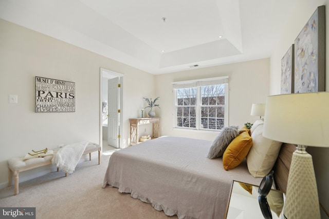 carpeted bedroom featuring visible vents and a raised ceiling