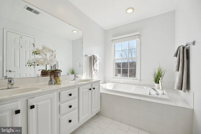 full bathroom featuring a bath, visible vents, tile patterned floors, and a sink