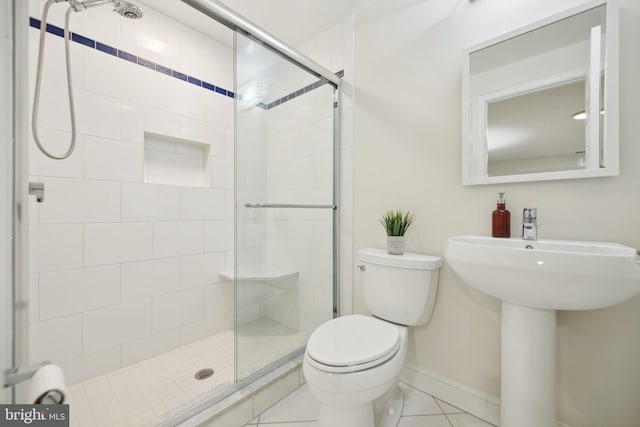 full bathroom with baseboards, toilet, a shower stall, and tile patterned flooring