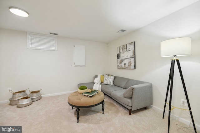 living area with visible vents, light colored carpet, and baseboards