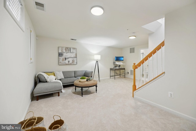 living area featuring visible vents, stairway, and carpet