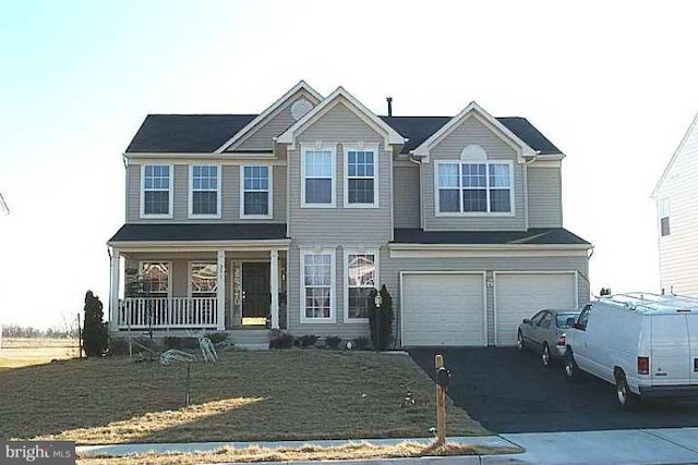 view of front of home with aphalt driveway, a porch, and an attached garage