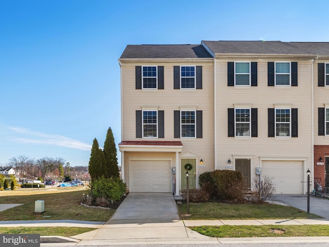 townhome / multi-family property featuring driveway and an attached garage