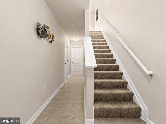 staircase with tile patterned floors and baseboards