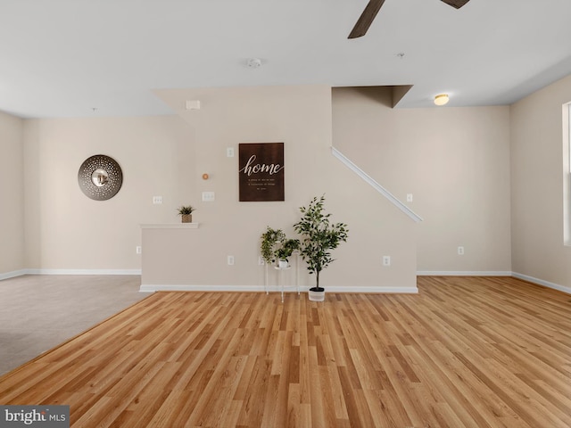 unfurnished living room with baseboards, light wood finished floors, and ceiling fan