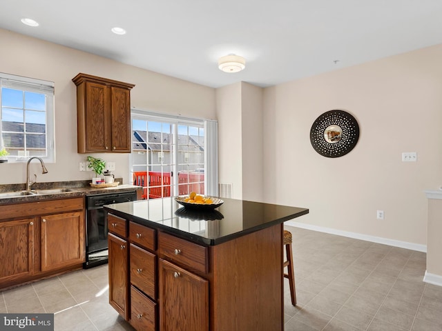 kitchen featuring a sink, a wealth of natural light, black dishwasher, and a breakfast bar area