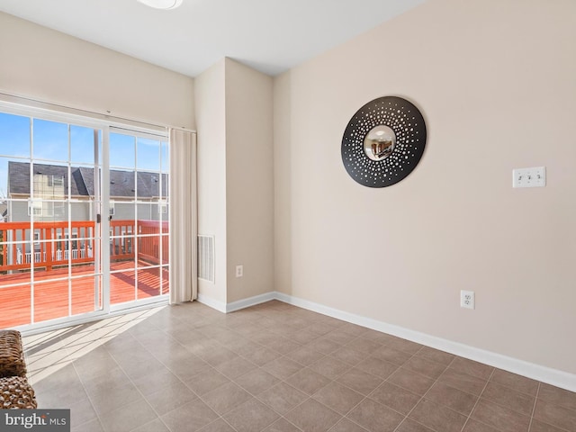 tiled empty room featuring visible vents and baseboards