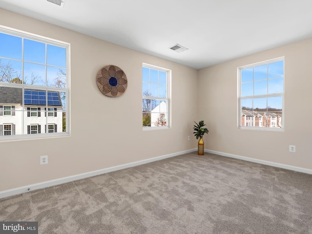 carpeted empty room with baseboards and visible vents