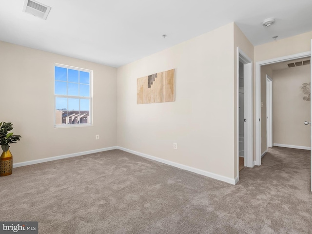 spare room featuring visible vents, baseboards, and carpet flooring