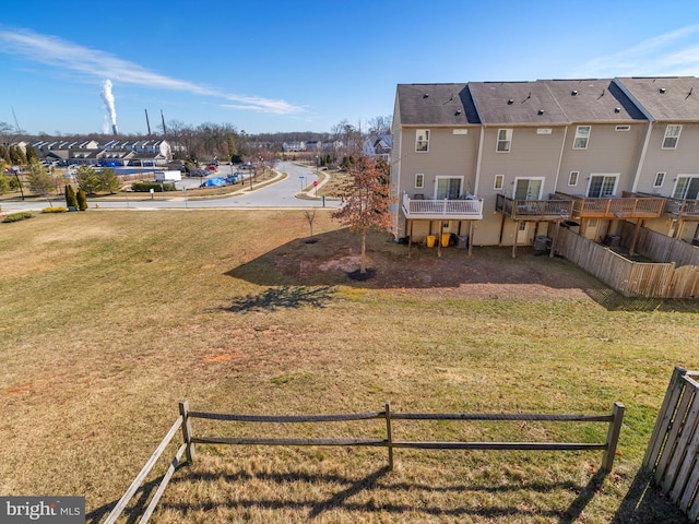 view of yard featuring a residential view, a deck, and fence