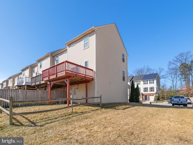 rear view of property featuring a residential view, a yard, and fence