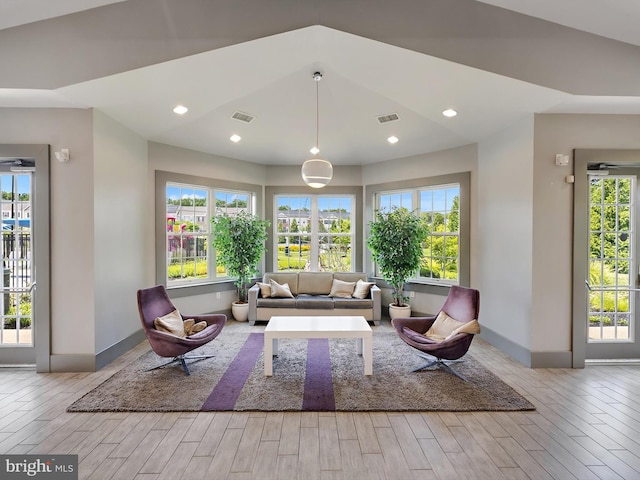 unfurnished living room featuring wood finished floors, visible vents, and a wealth of natural light