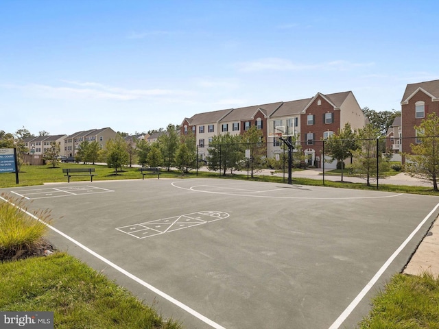 view of basketball court featuring community basketball court, fence, and a residential view