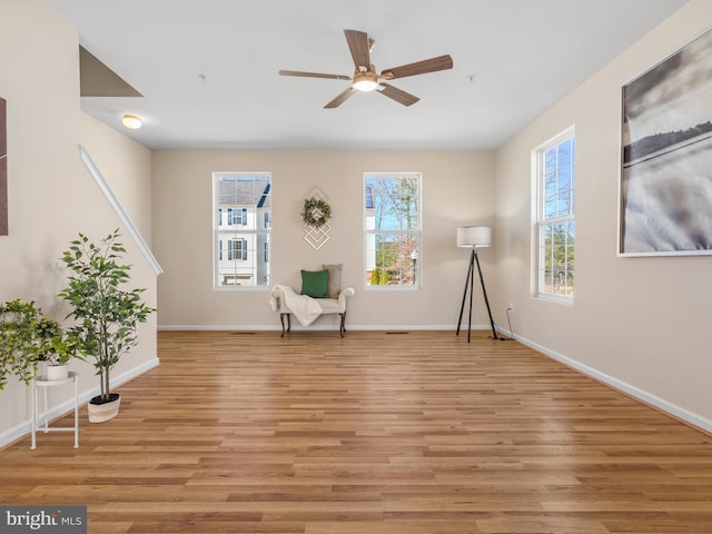 unfurnished room with baseboards, a healthy amount of sunlight, and light wood-style flooring