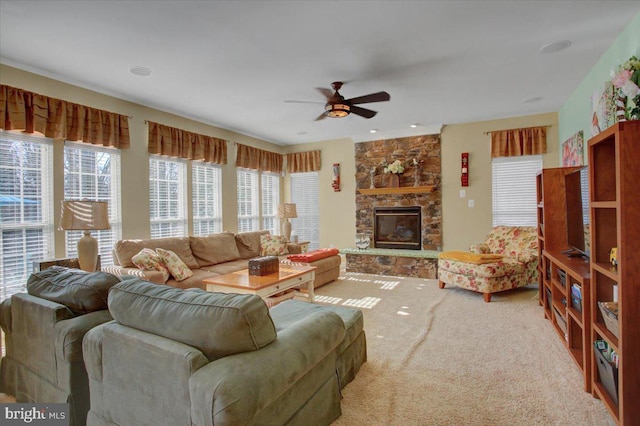 carpeted living area featuring plenty of natural light, ceiling fan, and a fireplace