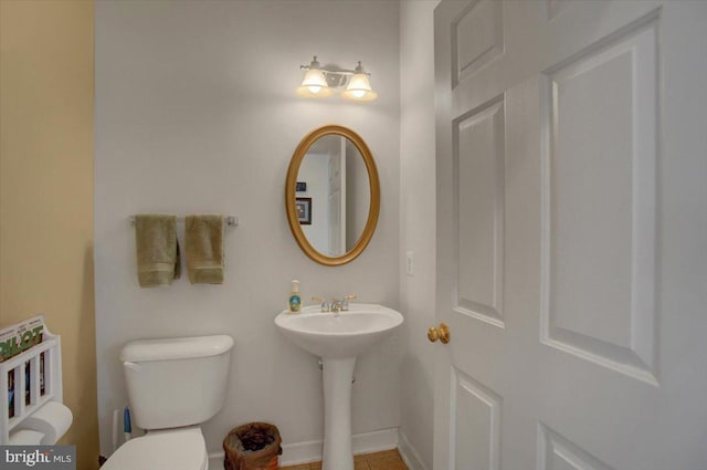 bathroom featuring toilet and baseboards