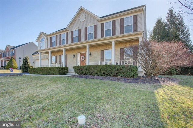 view of front of house featuring brick siding, covered porch, and a front yard