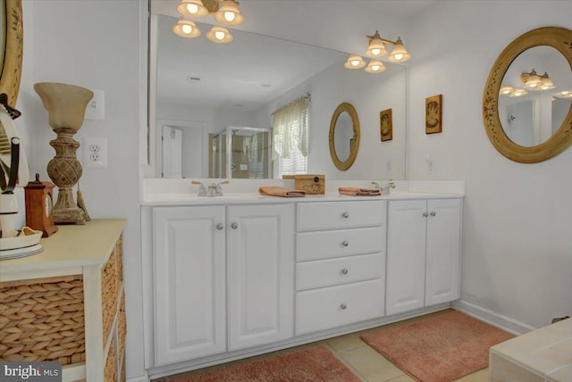 full bathroom with double vanity, a stall shower, a sink, and tile patterned flooring