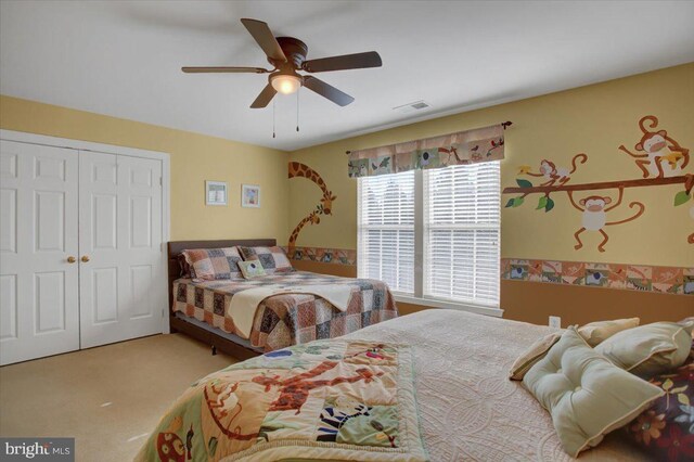 bedroom with carpet flooring, visible vents, a closet, and ceiling fan