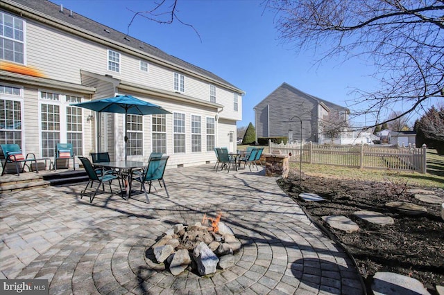 view of patio / terrace featuring outdoor dining space, fence, and an outdoor fire pit