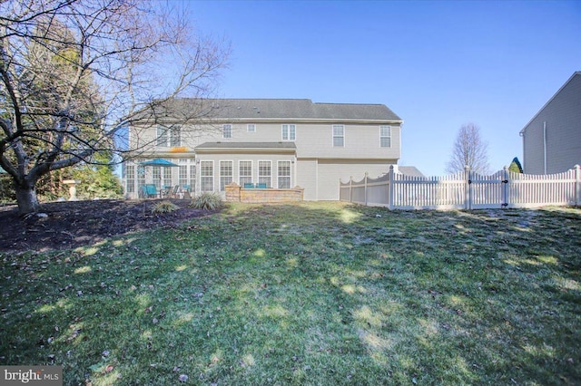 rear view of property featuring a yard and fence