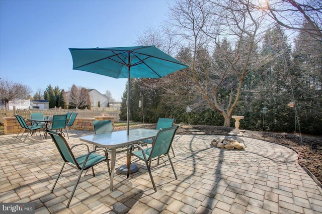 view of patio featuring outdoor dining area and fence