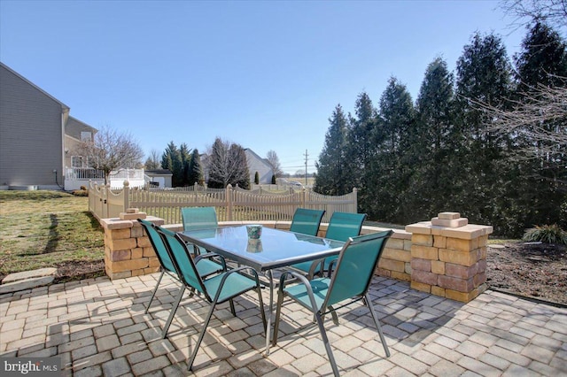 view of patio featuring outdoor dining area and fence