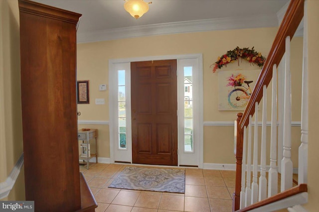 entrance foyer with tile patterned floors, stairway, baseboards, and ornamental molding