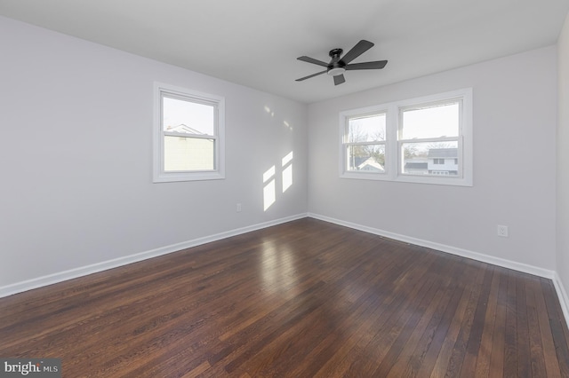 unfurnished room featuring dark wood finished floors, baseboards, and a wealth of natural light