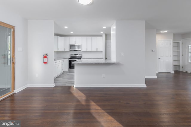 kitchen featuring baseboards, recessed lighting, dark wood-style flooring, white cabinets, and appliances with stainless steel finishes