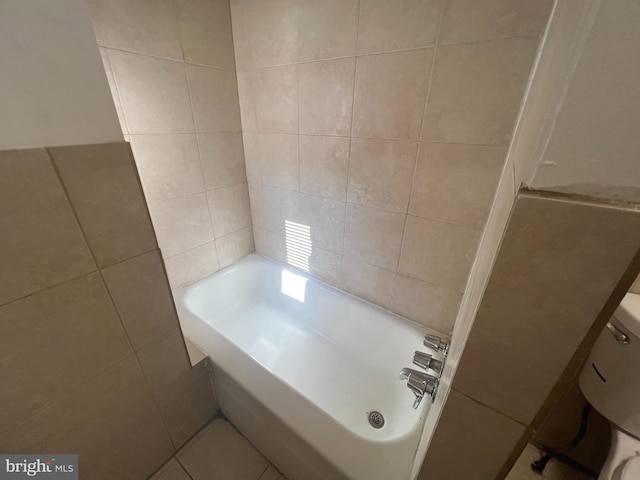 bathroom with tile walls and a tub