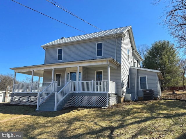 view of front of home with a porch, metal roof, a standing seam roof, a front lawn, and central AC