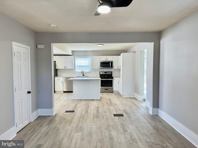 kitchen featuring a sink, stainless steel appliances, backsplash, and visible vents