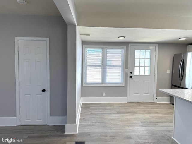 entryway with light wood-style floors and baseboards