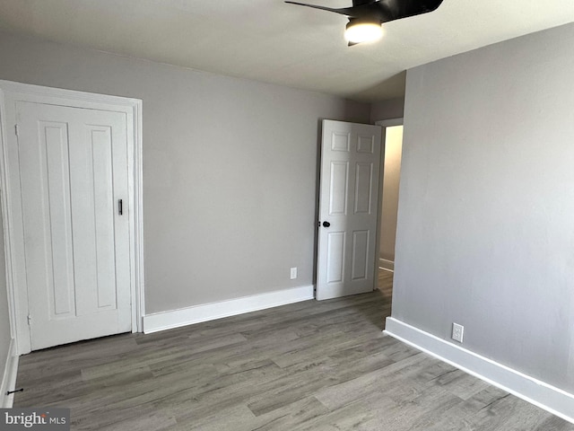 unfurnished bedroom featuring a ceiling fan, baseboards, and wood finished floors