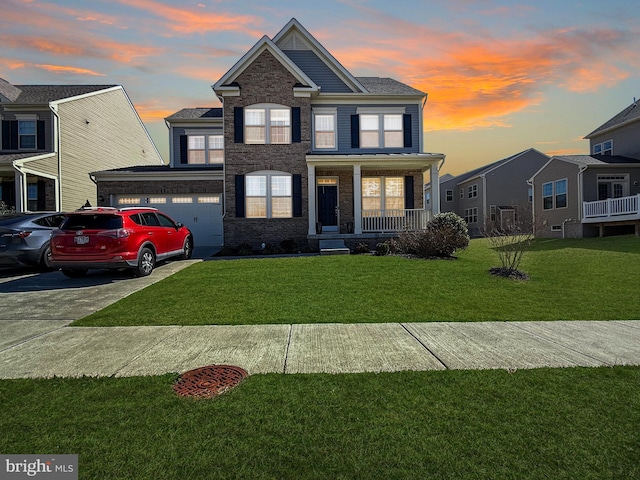 view of front facade featuring a porch, a yard, concrete driveway, an attached garage, and brick siding