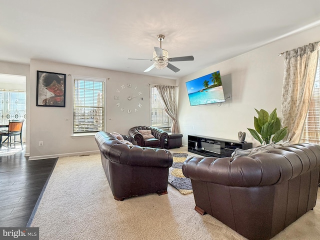 living area with wood finished floors, baseboards, and ceiling fan