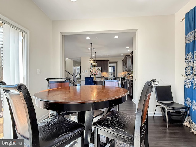 dining area featuring recessed lighting, baseboards, dark wood finished floors, and stairs